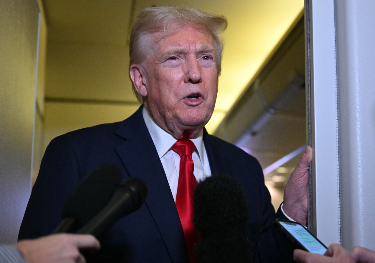 圖為2025年4月13日,美國總統特朗普在空軍一號上對記者講話。(Mandel NGAN / AFP)