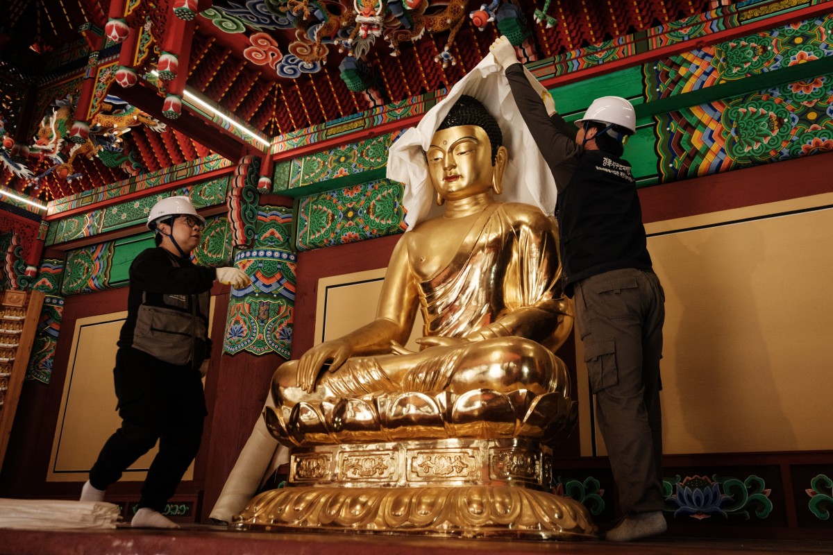 2025年3月25日,南韓義城,高雲寺(Gounsa Temple)面臨山火威脅,慶北西部文化遺產保護中心(Gyeongbuk Seobu Cultural Heritage Care Center)成員在完成前一晚其它文物撤離後,將一尊佛像以棉布與防火毯包裹,加強保護。 (YASUYOSHI CHIBA/AFP)