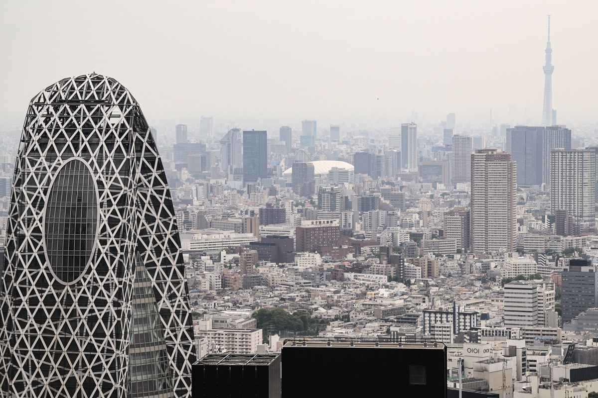 據日本總務省估算,截至2025年9月14日,日本65歲及以上人口佔比創新高,達29.4%。圖為2025年5月16日,在東京新宿商業區,高樓林立間可見白色屋頂的東京巨蛋與遠處東京晴空塔,在朦朧天色中若隱若現。(Richard A. Brooks/AFP)
