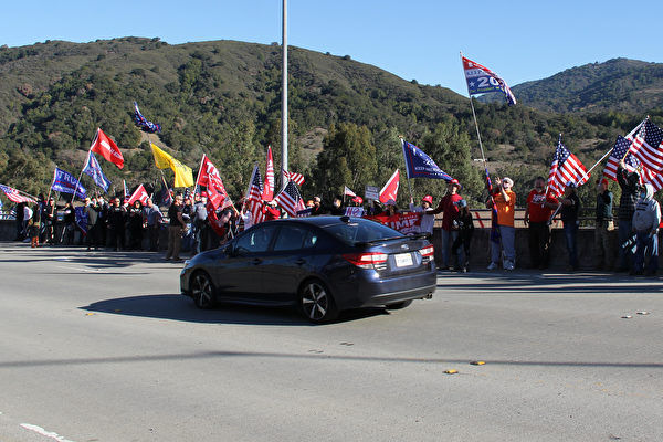 12月19日，在洛斯阿圖斯（Los Gatos）參加集會的民眾，站在路邊，高舉美國國旗等旗幟，向過往車輛揮舞，聲援特朗普，反對竊選。（大紀元）