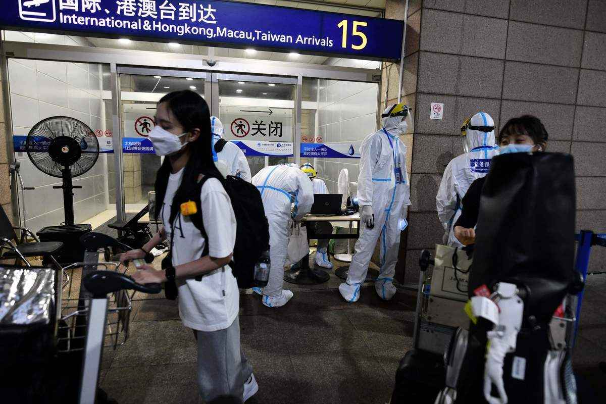 示意圖：2021年8月13日，在上海浦東機場，身著防護服以預防COVID-19的工作人員幫助到港的國際乘客準備登上巴士前往隔離酒店。（Greg Baker/AFP via Getty Images）