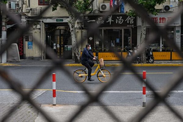 上海靜安區被封鎖期間街道上騎單車的居民。攝於2022年5月19日。（Hector Retamal/AFP via Getty Images）