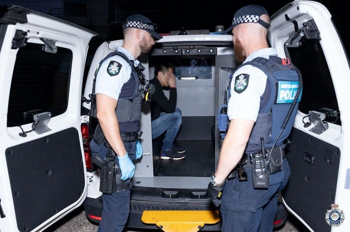 2023年2月1日被澳洲警方逮捕的華人疑犯以手遮面。（澳洲聯邦警察）
