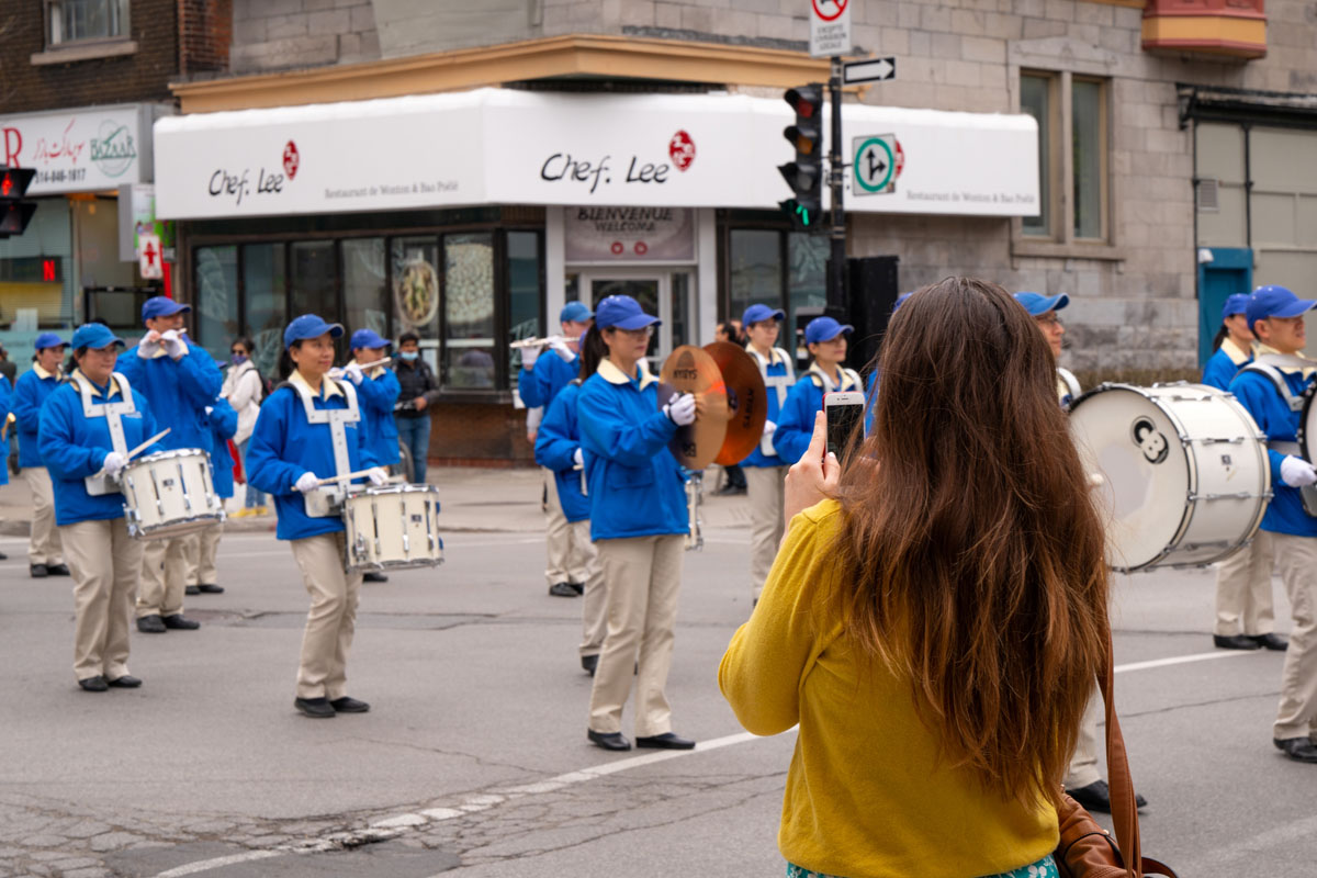 5月8日，加拿大魁北克部份法輪功學員在滿地可舉行遊行活動，慶祝世界法輪大法日。遊行隊伍吸引民眾駐足觀看拍照。（大紀元）