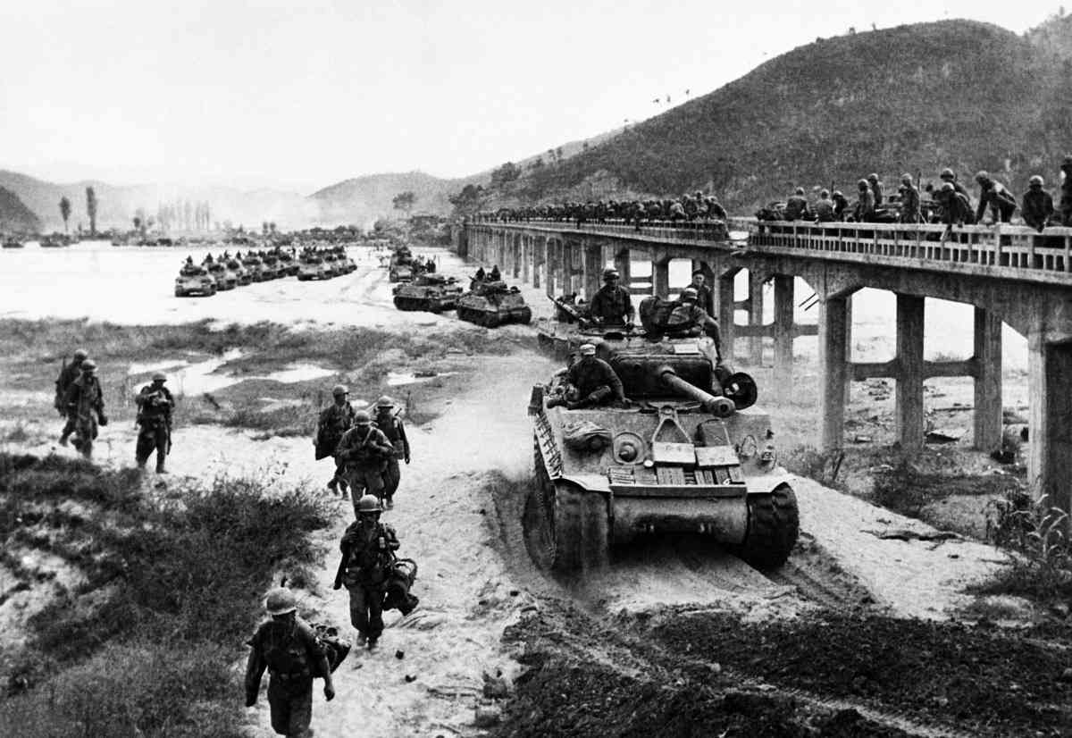 1950年10月17日,美軍第1步兵師的坦克穿越韓國黃江,旁邊是一座受損的橋樑。(AFP via Getty Images)