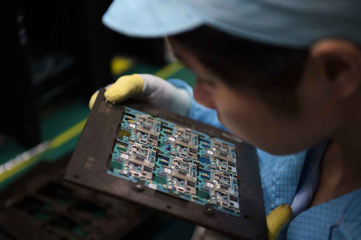 受疫情等因素影響，中國射頻晶片龍頭卓勝微公司總市值一年來已蒸發約1,234億元。圖為一名東莞工人正在查看手機晶片。（NICOLAS ASFOURI/AFP/Getty Images）