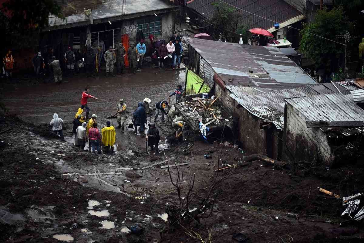 2025年10月11日,墨西哥普埃布拉州瓦烏奇南戈市(Huauchinango)遭暴雨襲擊後,蒙特雷(Monterrey)一社區附近發生大規模山泥傾瀉,多棟民宅遭到損毀。圖為人們正在現場進行清理工作。(Alfredo Estrella/AFP via Getty Images)