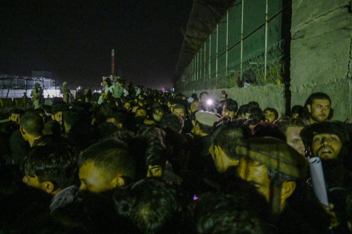 深夜中，阿富汗人等候在喀布爾機場的外國軍事控制區外，希望在塔利班軍事接管阿富汗後逃離阿富汗。攝於2021年8月22日。（Wakil Kohsar/AFP via Getty Images）