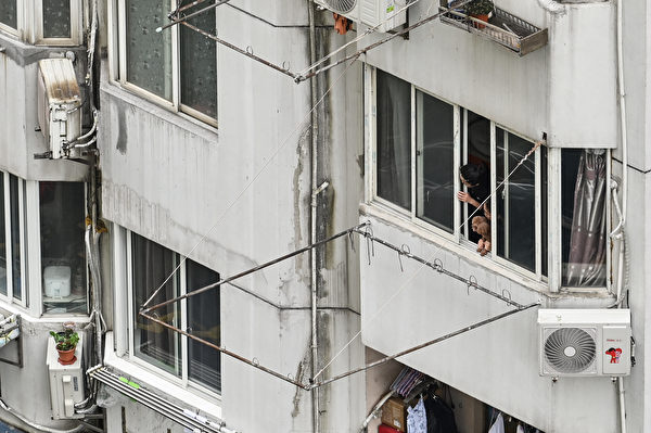 上海多小區封控超過一個月。圖為2022年4月23日，上海一棟居民樓遭到封鎖，居民和寵物不得下樓。（Hector Retamal/AFP via Getty Images）