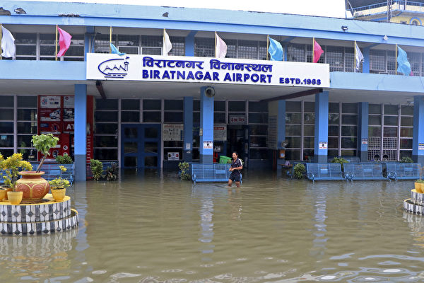 http://2021年10月20日,尼泊爾比拉德訥格爾(Biratnagar),豪雨成災,機場入口處一位市民涉水通行。(LILA BALLAV GHIMIRE/AFP via Getty Images)