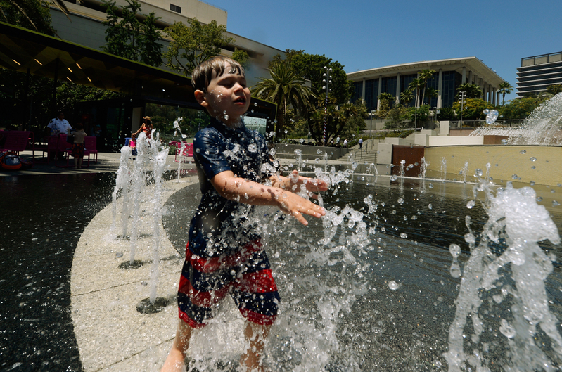 2016年6月28日加州洛杉磯市中心一名兒童在噴水池中嬉戲消暑。（Kevork Djansezian/Getty Images）
