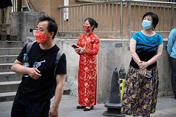 2022年6月7日在北京，第一天全國高考（NCEE），家長們在校外等候。有家長特意穿上旗袍、紅衣，寓意「開門紅」、「旗開得勝」。（Jade Gao/AFP via Getty Images）