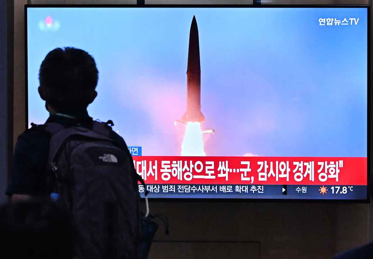2022年10月1日，北韓向東部海域發射了兩枚短程彈道導彈，這是平壤一周內第四度試射。圖為2022年9月29日，首爾一個火車站裏，一名男子走過一個電視屏幕，屏幕上顯示著北韓導彈試驗的資料畫面。（JUNG YEON-JE/AFP via Getty Images）