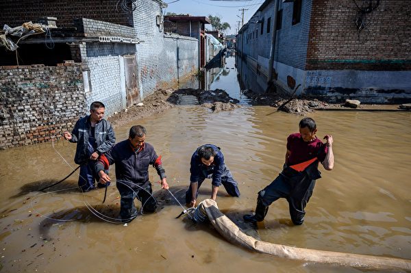 2021年10月11日，中國山西省晉中市介休市，暴雨造成洪災，救難人員正在抽除積水。（AFP via Getty Images）