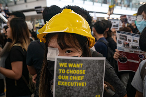 8.11一位少女被射穿右眼，8月12日港人在機場矇右眼抗議。（Anthony Kwan/Getty Images）