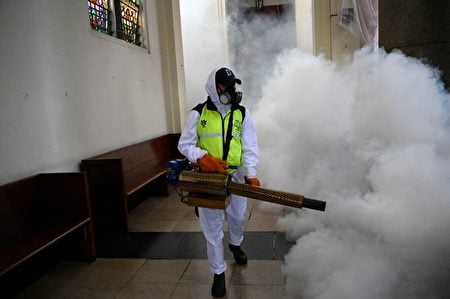 2023年8月30日,在危地馬拉城的Las Misericordias教堂,一名市政工作人員對登革熱、寨卡和基孔肯雅病毒的傳播媒介埃及伊蚊進行熏蒸消毒。(JOHAN ORDONEZ/AFP via Getty Images)
