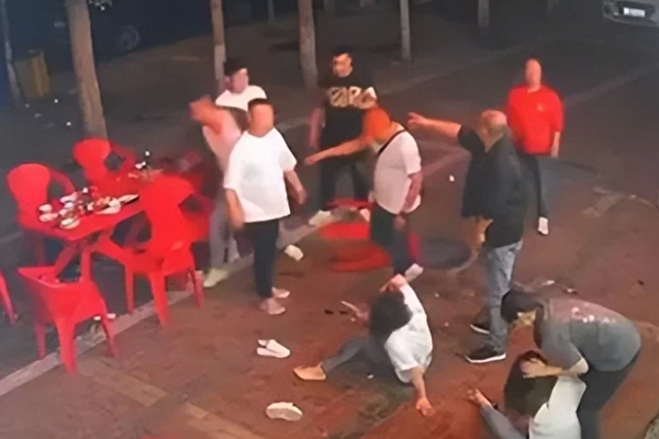 唐山打人事件現場，暴徒從店內打到店外，兩名女子被圍毆倒地。（影片截圖）