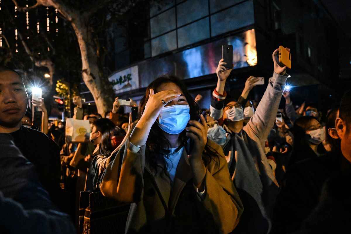 2022年11月26日起，中國多座城市出現民眾集會，表達反對封控的呼聲，多位參與市民遭到逮捕。有維權律師表示，民眾抗議並不違法，違法的是中共本身。圖為2022年11月27日上海的集會活動。（HECTOR RETAMAL/AFP via Getty Images）