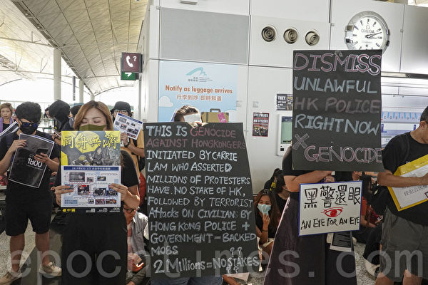 2019年8月12日，港人在香港機場展開「警察還眼」集會。圖為示威民眾舉著各式展板和標語表達抗議。（余鋼／大紀元）