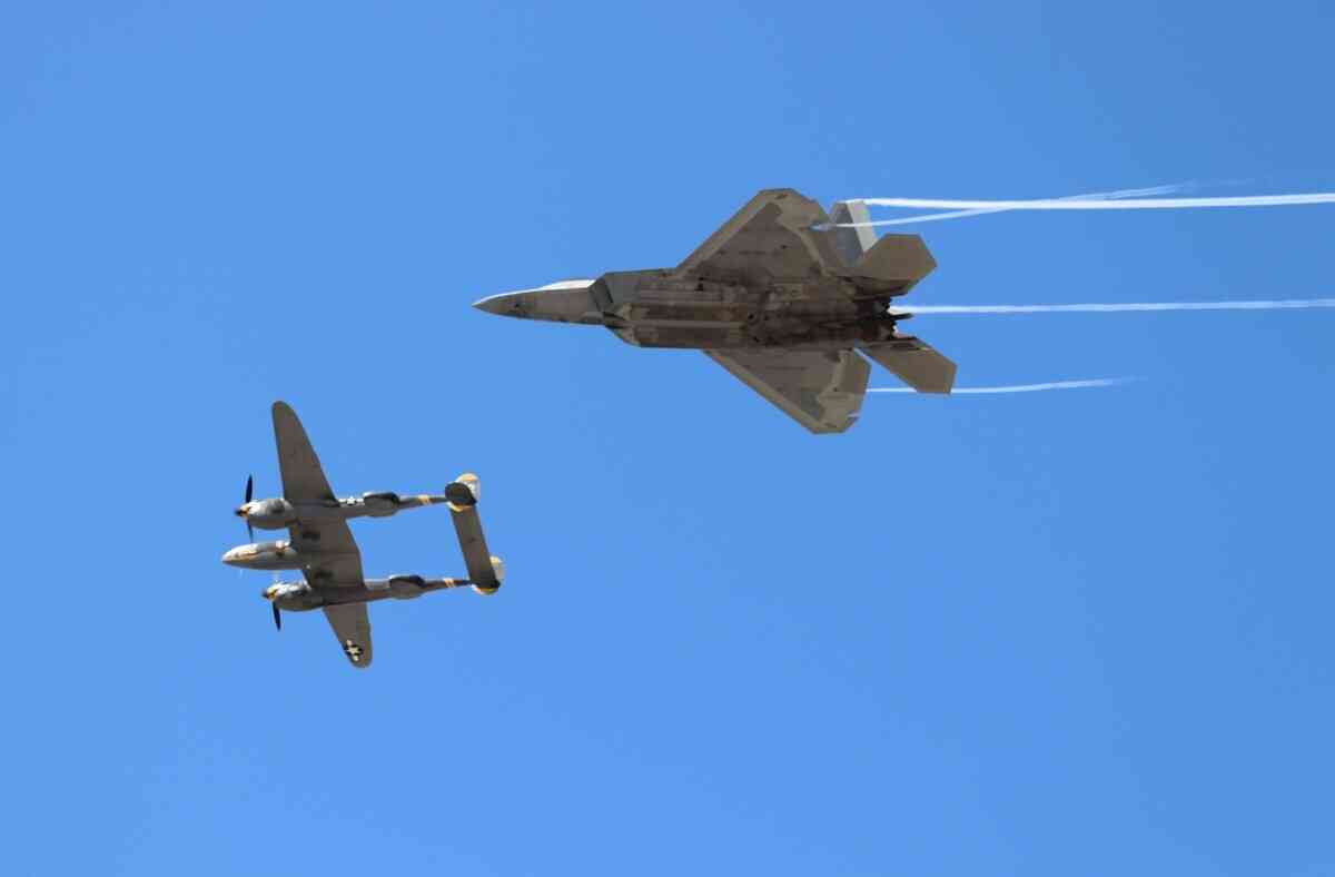 2025年9月25日,年度美國航空展(America's Air Show)舉行媒體預展。左為USMC P-38 Lightning閃電戰鬥機,它有兩個液冷式引擎,能夠在25,000呎以上的稀薄空氣中保持速度和火力。右為USMC F-22 Raptor猛禽戰鬥機。(李梅/大紀元)