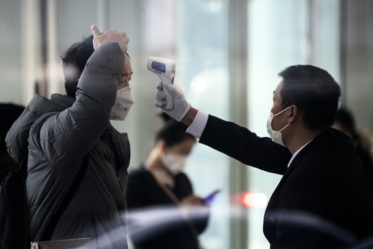 2020年2月10日，上海一所辦公樓的保安在檢查進入大樓人員的體溫。（NOEL CELIS/AFP via Getty Images）