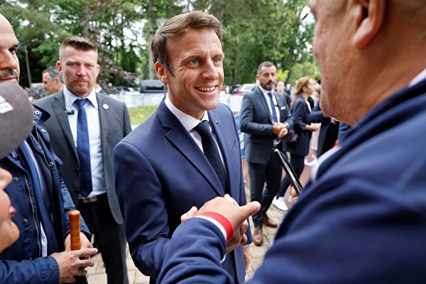 2022年6月19日，法國總統埃馬紐埃爾馬克龍（Emmanuel Macron，中）來到法國北部勒圖凱（Le Touquet）的一個投票站參加法國議會選舉第二階段投票，並與其他選民交談。（LUDOVIC MARIN/AFP via Getty Images）