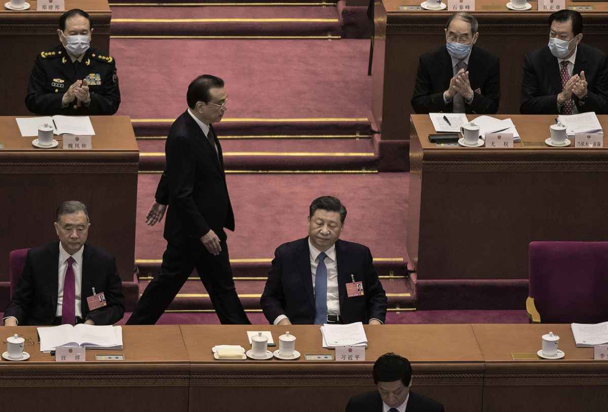 2022年3月5日的中共人大會議上，李克強從汪洋（左）和習近平（中）身後走過。 （Kevin Frayer/Getty Images）