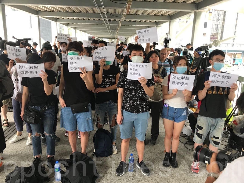 一批市民手持寫有「停止射擊香港人民」的紙張，在中信橋默站。（蔡雯文／大紀元）