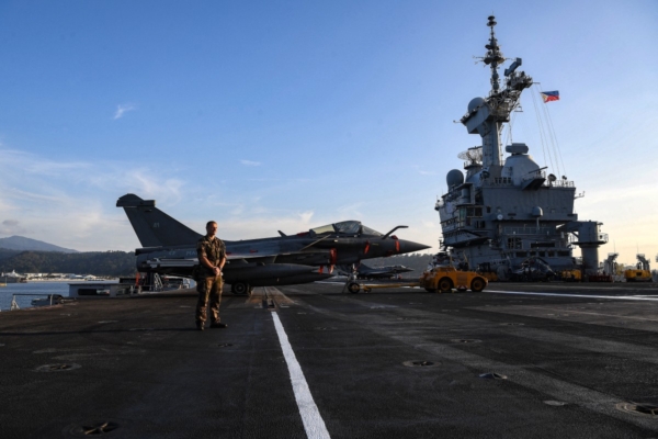 2025年2月23日,一名法國士兵在媒體參觀法國航空母艦戴高樂號飛行甲板上一架陣風戰鬥機前站崗,該航空母艦停泊在馬尼拉北部蘇比克灣的美國前海軍基地。 (Photo by TED ALJIBE / AFP)