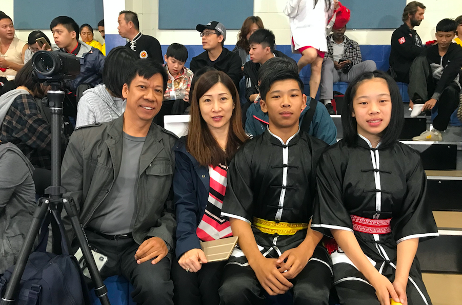 來自加拿大的專業武術教練李明洪（左一）夫婦帶一雙兒女參賽，兒子獲銀獎，母親、武術教練辛錦芳（左二）也想參賽。（趙芬妮／大紀元）