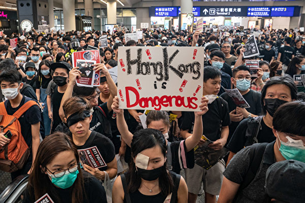 8.11一位少女被射穿右眼，8月12日港人在機場矇右眼抗議。（Anthony Kwan/Getty Images）