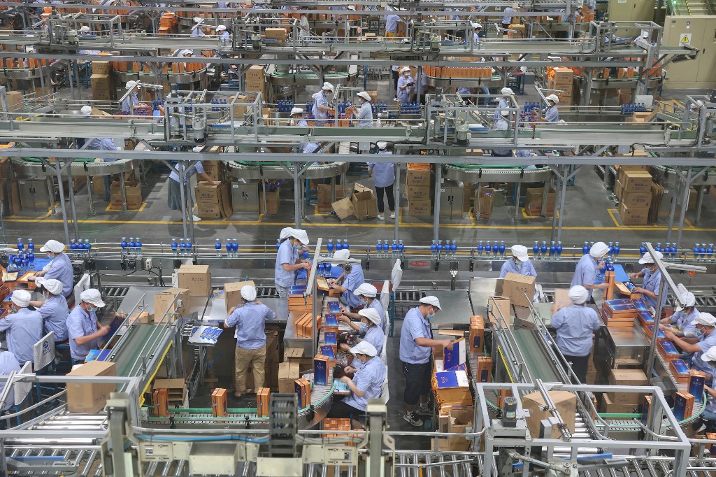​中國疫情重創經濟，12月製造業和服務業活動均萎縮。圖為2022年7月23日，工人在江蘇的一家工廠生產中國白酒。（ AFP）