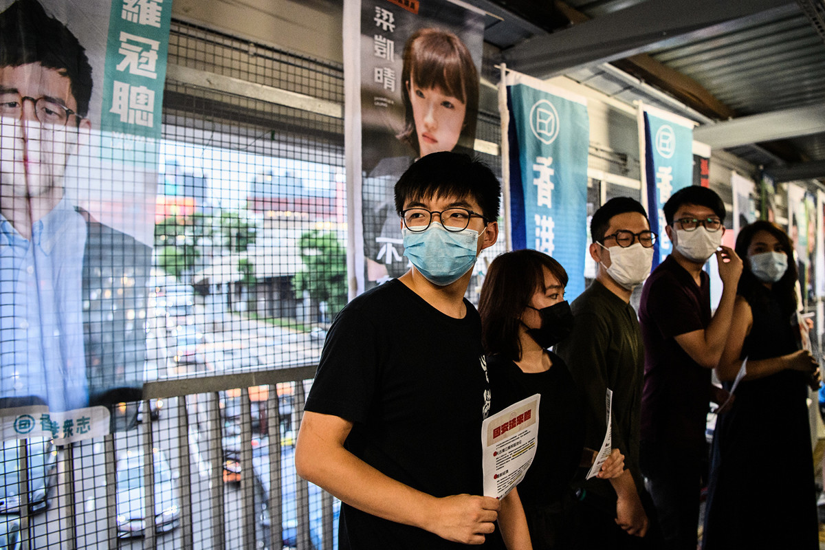 圖為香港民主活動人士黃之鋒等人2020年5月22日在分發傳單，反對中共在香港強推的「港版國安法」。（Anthony WALLACE / AFP）