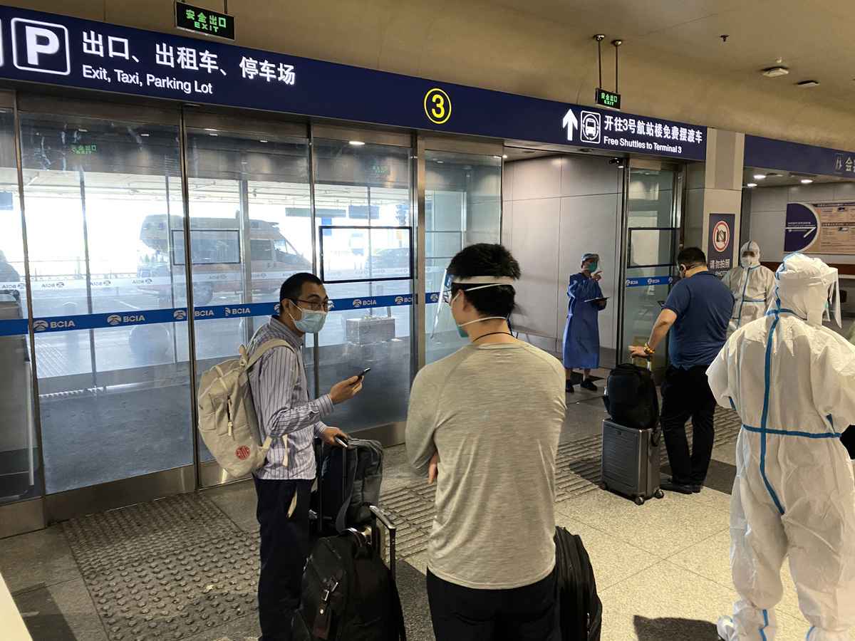2022年6月18日，北京國際機場的入境旅客正在等待被送往指定的檢疫隔離地點。（LEO RAMIREZ/AFP via Getty Images）