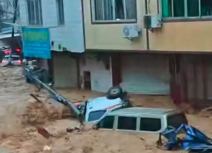 橫州市六藍水庫大壩6日上午被洪水沖出約50米缺口，洪水淹沒下游村莊。（影片截圖）