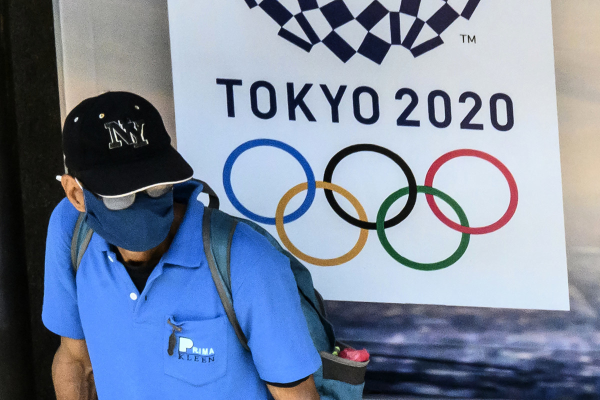 日本首相安倍晉三周二（3月24日）表示，原定於2020年7月24日在東京舉行的夏季奧運會，將推遲到2021年。圖為一名男子走過2020年東奧廣告牌前。（Photo by Mladen ANTONOV/AFP）