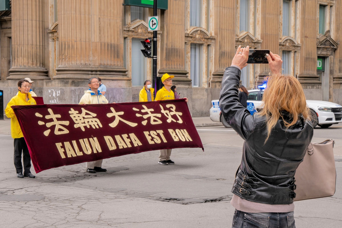 5月8日，加拿大魁北克部份法輪功學員在滿地可舉行遊行活動，慶祝世界法輪大法日。遊行隊伍吸引民眾駐足觀看拍照。（大紀元）