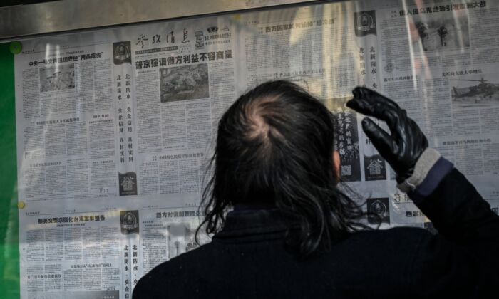 2022年2月24日，一名男子在北京的一條街道上閱讀中國官方報紙報道俄羅斯與烏克蘭之間衝突的文章。文章支持俄羅斯入侵。（Jade Gao/AFP via Getty Images）