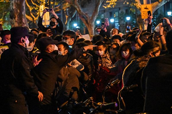 2022年11月26日晚，上海街頭爆發民眾要求中共下台的抗議。圖為27日，在上海仍可看到一些民眾與警察發生衝突。（Hector RETAMAL / AFP）