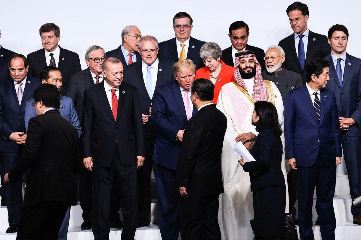 圖為2019年6月28日，特朗普總統與習近平在G20峰會拍大合照前握手。（BRENDAN SMIALOWSKI/AFP/Getty Images）