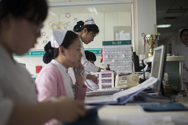 中共的「醫療反腐」已經進行了一段時間，近期許多醫院醫護出現降薪潮，北京同仁醫院醫生績效收入減半。圖為北京同仁醫院的醫護人員。（Fred Dufour/AFP）