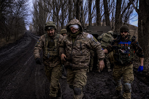 2023年3月8日，巴赫穆特（Bakhmut）附近，在俄烏戰爭期間，烏克蘭醫務兵協助一名受傷的烏克蘭士兵撤離。（Sergey Shestak/AFP）