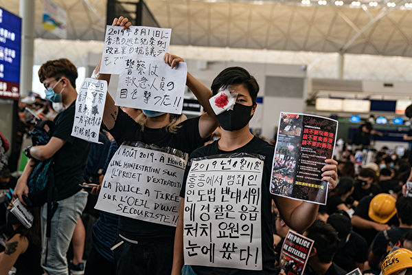 8.11一位少女被射穿右眼，8月12日港人在機場矇右眼抗議。（Anthony Kwan/Getty Images）