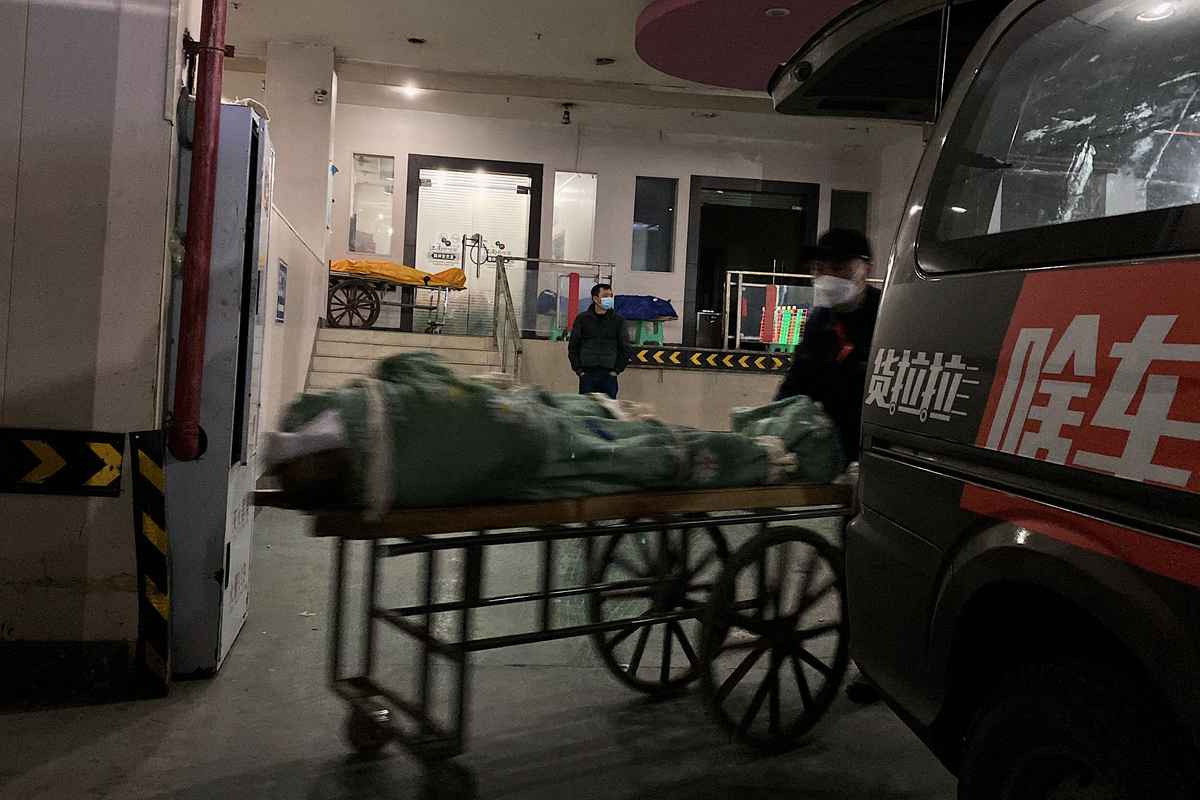 2022年12月22日，重慶的火葬場，喪葬人員將屍體裝上手推車進行火化。（Noel Celis / AFP）