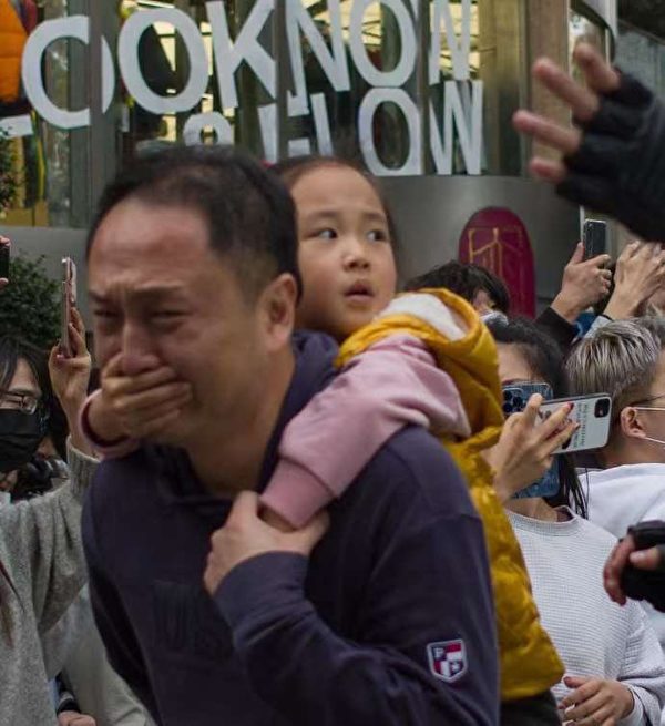 2022年上海白紙運動期間，一位小女孩為保護爸爸摀住爸爸的嘴。（網絡圖片）