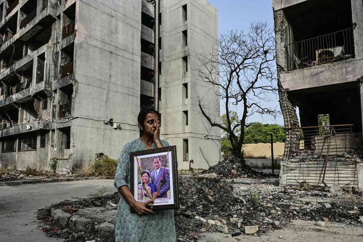 2026年6月11日，一名婦女手持去年在印度航空171航班空難中罹難親屬的肖像，在參觀印度艾哈邁達巴德（Ahmedabad）的事故現場時泣不成聲。在2025年印度航空波音787空難（造成260人死亡）的周年紀念日到來之際，印度航空事故調查機構再次面臨來自飛行員團體的批評。罹難者家屬原本希望在6月12日之前收到一份最終報告來解釋這場災難的原因，而這天正是該波音787-8飛機在起飛後不久即化作火球墜毀並撞向一所醫學院的一周年。（Shammi Mehra/AFP via Getty Images）