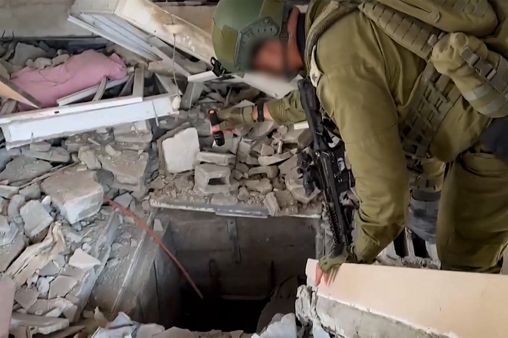 哈馬斯在加沙擁有龐大的地下通道網。哈馬斯將其用作總部或武器儲存地。圖為以色列軍方於2023年11月3日發布的影片顯示，一名以色列士兵正在檢查一個哈馬斯使用的地下通道入口。（Israeli Army / AFP）