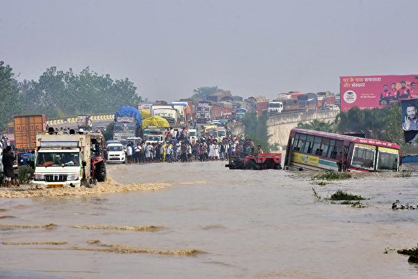 2021年10月20日，印度北方邦（Uttar Pradesh），豪雨導致科西河（Kosi river）氾濫、交通受阻。（AFP via Getty Images）