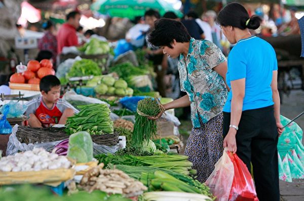 中國婦女在北京菜市場挑選蔬菜。（TEH ENG KOON/AFP/Getty Images）