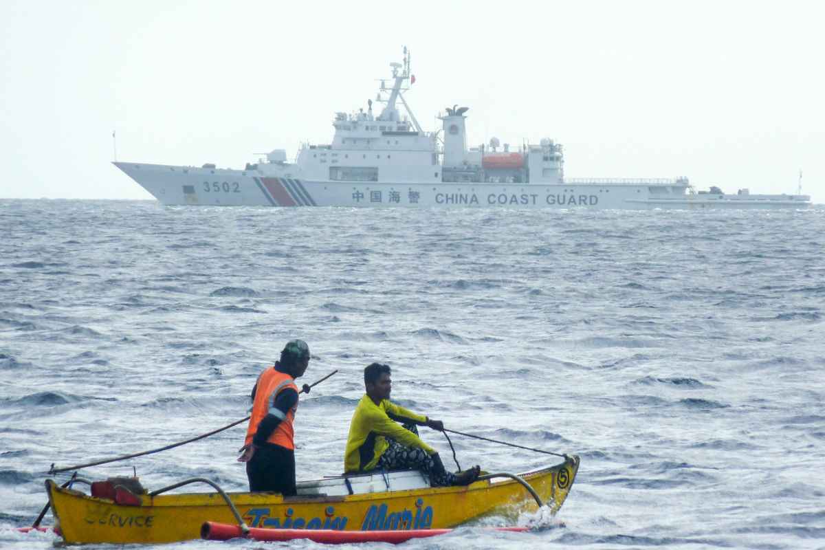 中共和菲律賓在南海的爭端越演越烈。2023年9月24日，菲律賓譴責中共在南海設置浮動屏障，阻礙菲律賓漁民進入。圖為2022年12月23日，中共海警船出現在菲律賓漁民捕魚的南海黃岩島一帶海域。（STR / AFP）